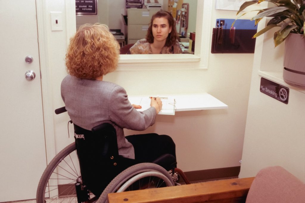 femme en chaise roulante demandant des informations